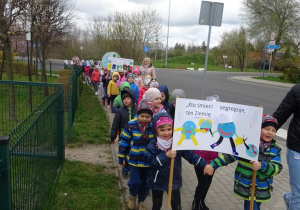 Dzieci maszerują ulicami osiedla z transparentami ekologicznymi, skandują hasła ekologiczne.